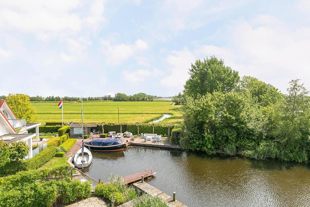 Ein Boot liegt an einem Dock auf einem Fluss. in der Unterkunft Villa Envie in Terherne