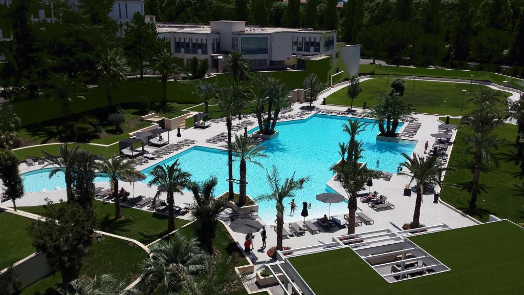 vista sul tetto di una piscina del resort con palme di Ergife Palace Hotel a Roma