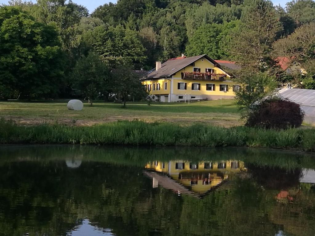 ein Haus im Wasser eines Sees reflektiert in der Unterkunft Frühstückspension Krump in Bad Waltersdorf