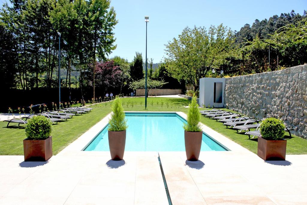 una piscina con piante in vaso in giardino di Casa do Passal Country House a Paço de Sousa