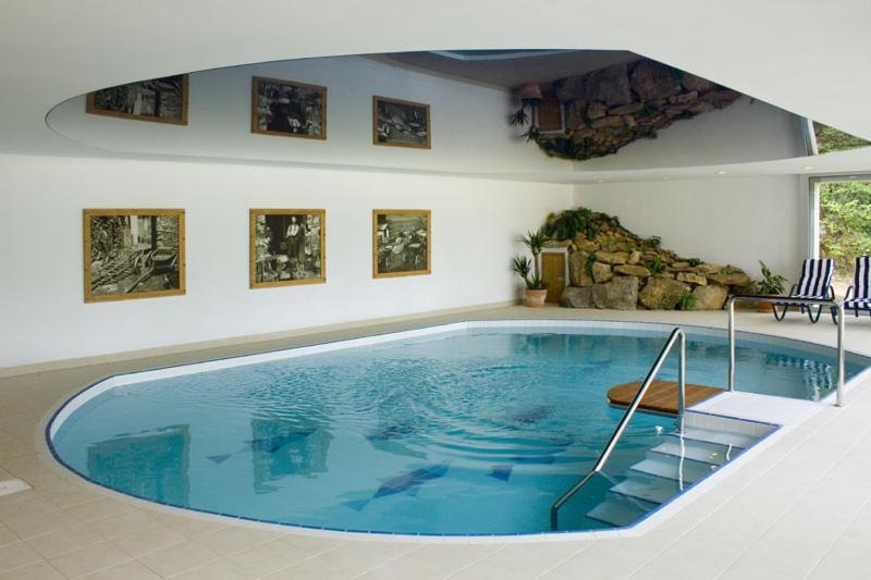 a large blue swimming pool in a room at Wellness Hotel Svachovka in Český Krumlov