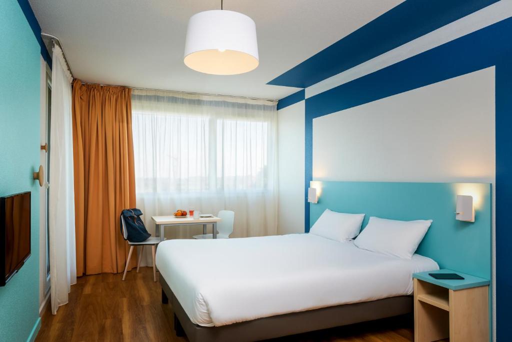 A bed or beds in a room at Aparthotel Adagio Access Strasbourg Illkirch