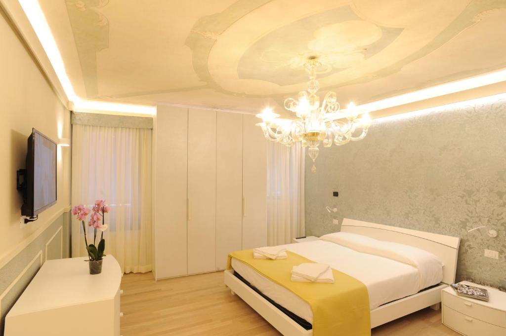 um quarto com uma cama e um lustre em CA' XXII MARZO BOUTIQUE em Veneza