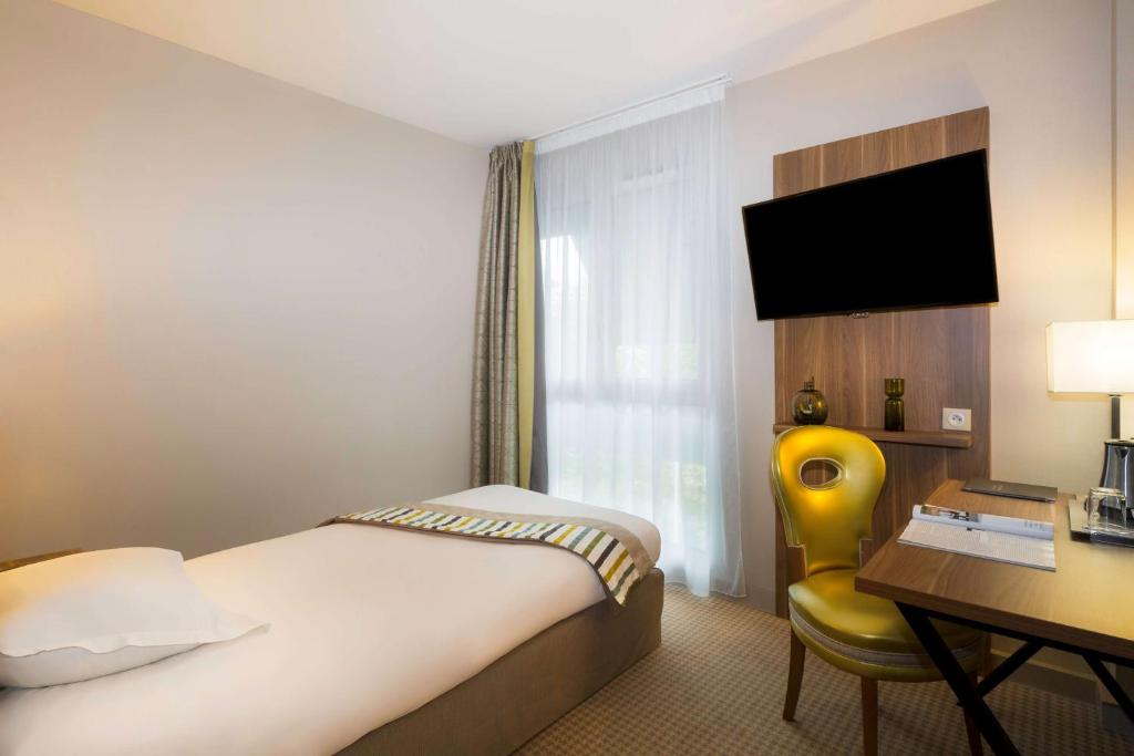 Een TV en/of entertainmentcenter bij Best Western Plus Hotel Du Parc Chantilly
