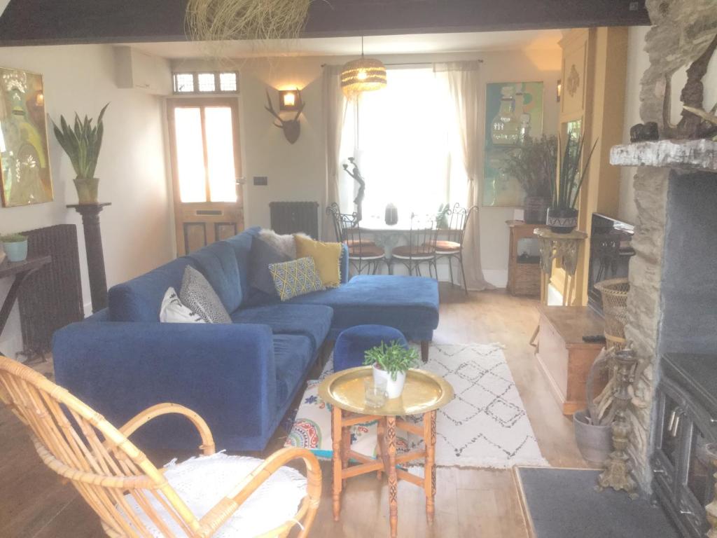 - un salon avec un canapé bleu et une table dans l'établissement Bambu Cottage, à Newquay