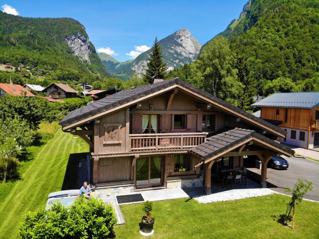 eine Luftansicht eines Hauses mit Bergen im Hintergrund in der Unterkunft Chalet Luxe Les Mélèzes in Samoëns