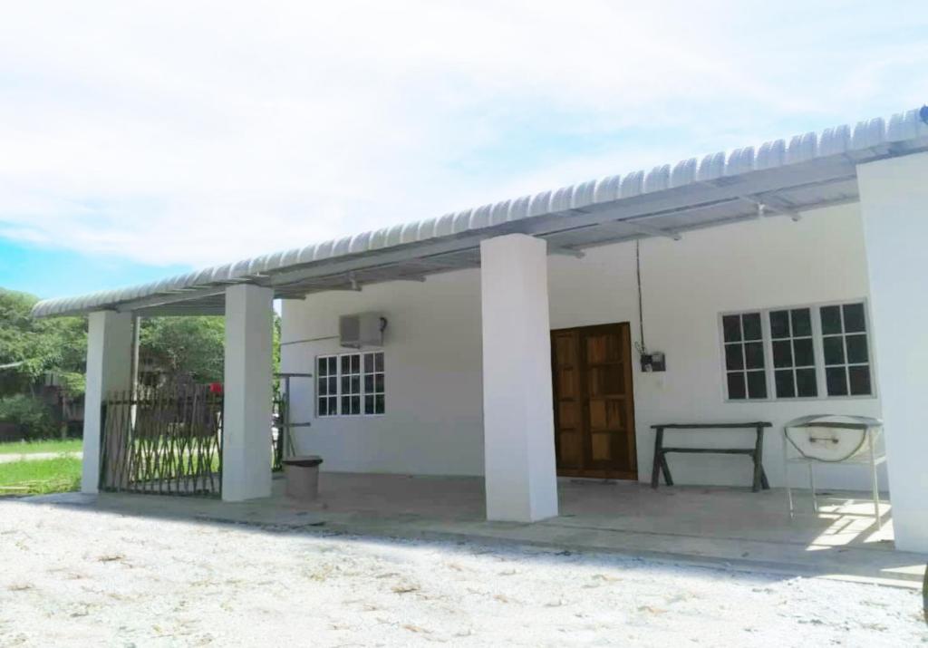 ein kleines weißes Haus mit einer Veranda in der Unterkunft Homestay Langkawi Airport in Kampung Padang Masirat