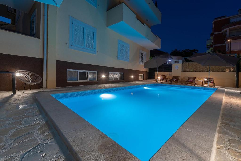 una piscina nel mezzo di un edificio di notte di Apartments Dijana a Zara (Zadar)