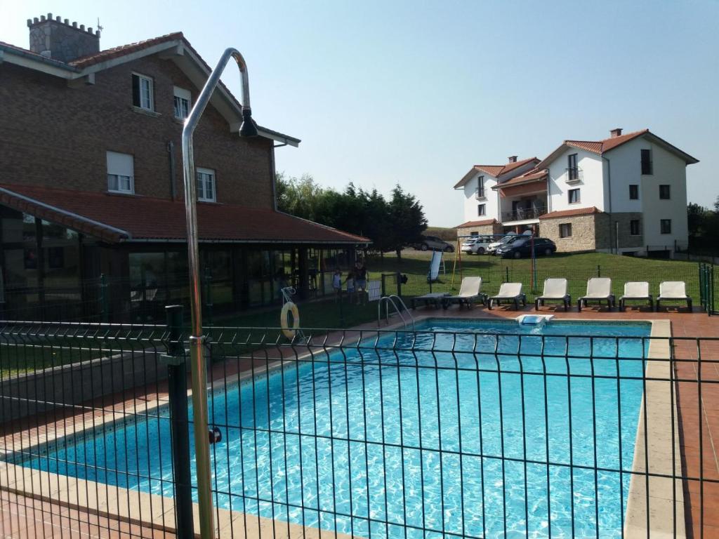 une piscine entourée d'une clôture dans l'établissement Apartamentos La Pradera de Isla, à Isla