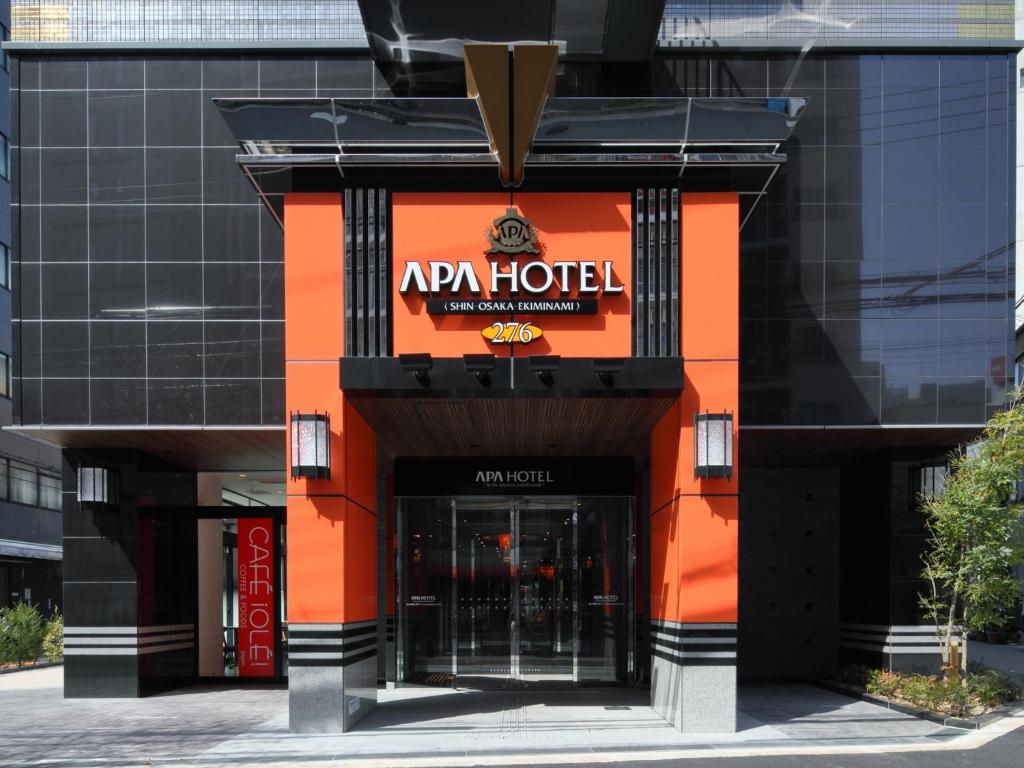 an entrance to a hotel with an orange and black facade at APA Hotel Shin Osaka Ekiminami in Osaka