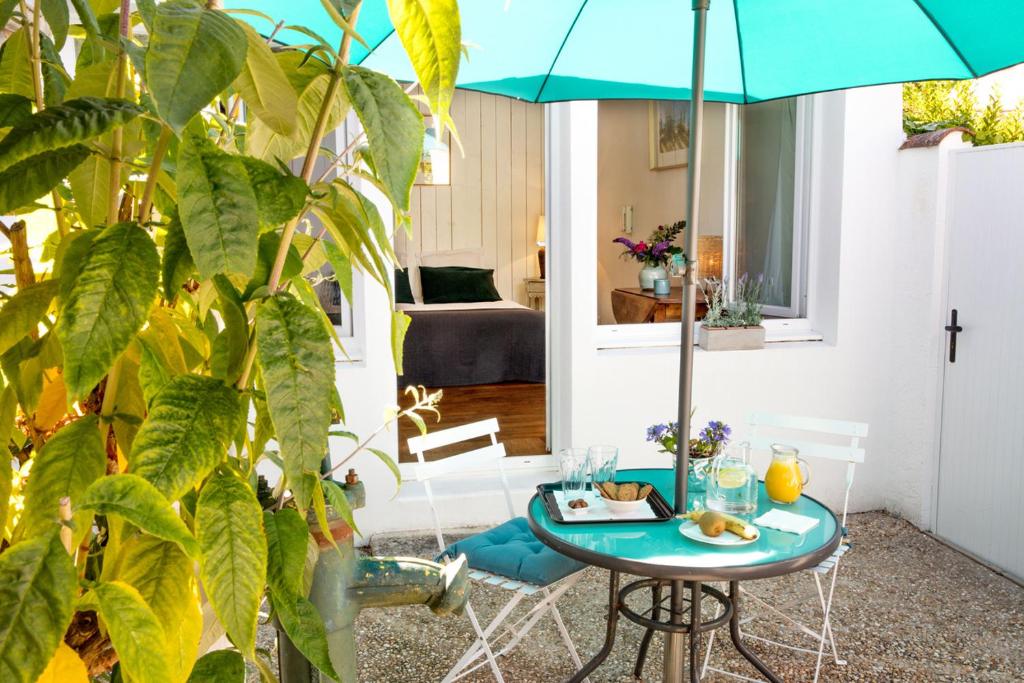 une chambre avec une table et un parasol dans l'établissement La Venelle de Jéricho, à La Rochelle