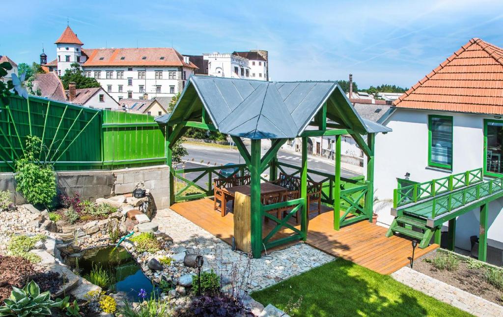 een groen prieel met een picknicktafel op een terras bij Penzion-apartmán Souček in Jindrichuv Hradec