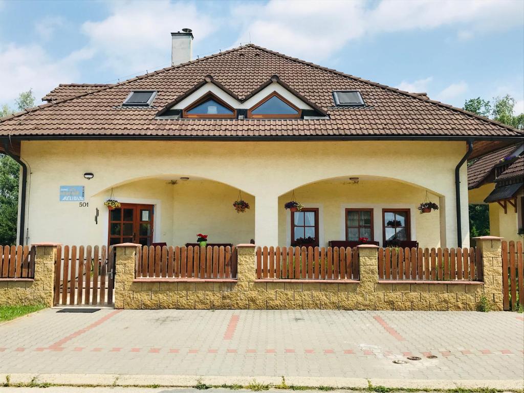 une maison avec une clôture en bois devant elle dans l'établissement Penzion Bělidlo, à Kunžak