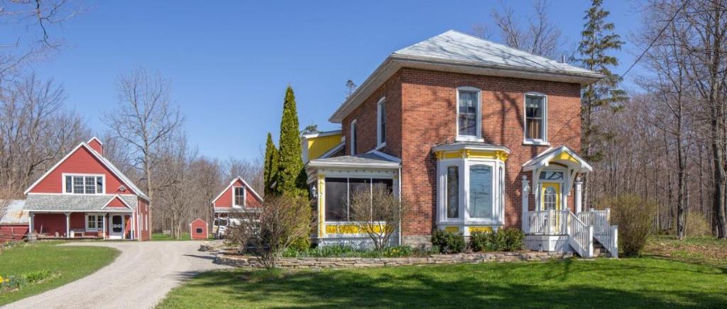 a red brick house on a dirt road at Our Space the Perfect Place B&B in Picton