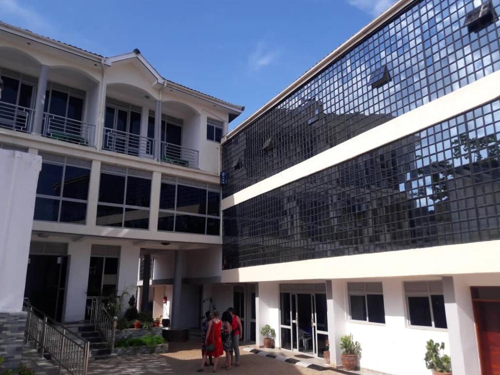 un groupe de personnes debout devant un bâtiment dans l'établissement Victoria Panorama Hotel, à Jinja