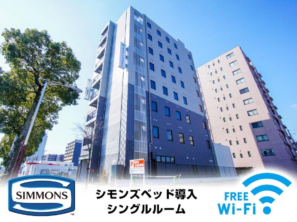 un edificio con una señal delante de él en HOTEL LiVEMAX Himeji Shiyakusho Mae, en Himeji