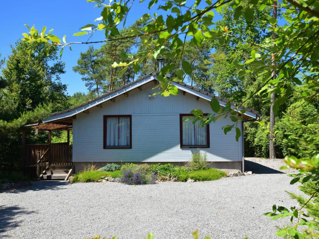 バルヴォーにあるCosy chalet in Barvaux with fenced gardenの黒窓と私道のある白い家