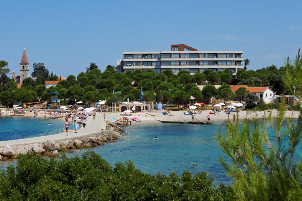 uma praia com pessoas e um edifício ao fundo em Maistra Select All Suite Island Hotel Istra em Rovinj