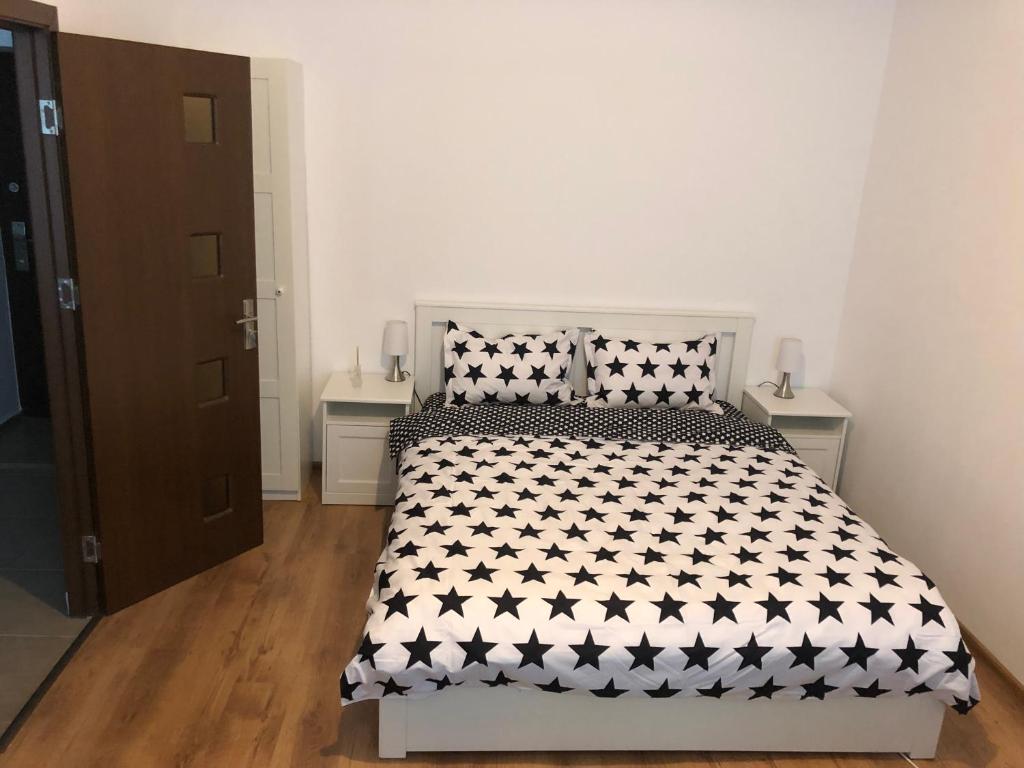 een slaapkamer met een bed met een zwart-wit dekbed bij Poppys Apartment in Arad