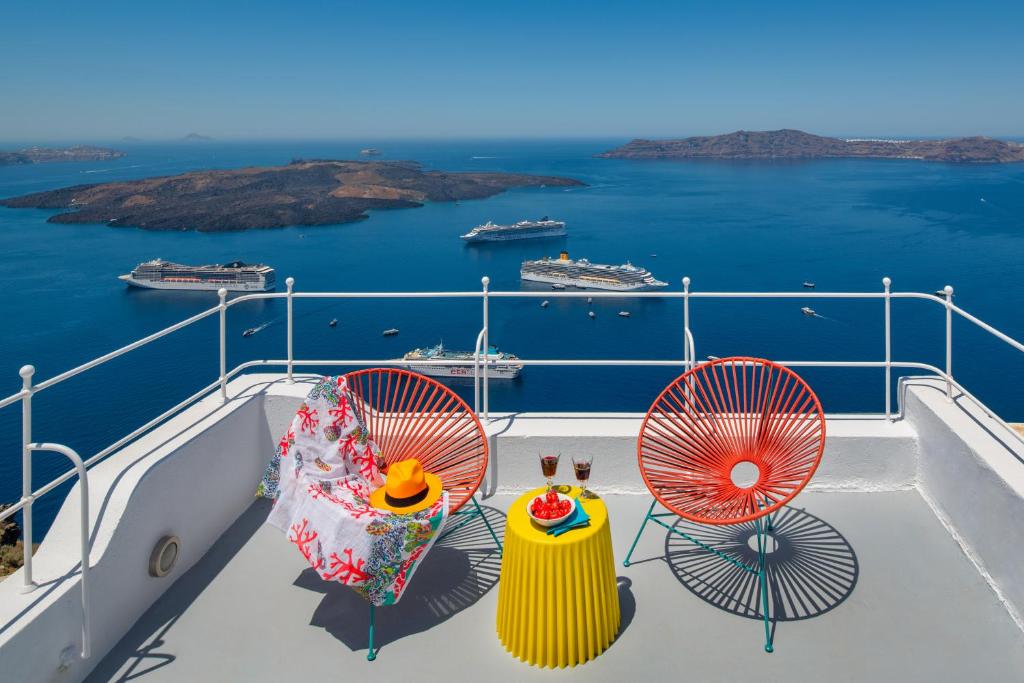 een balkon met 2 stoelen en uitzicht op de oceaan bij Barocco Bello Villa in Fira