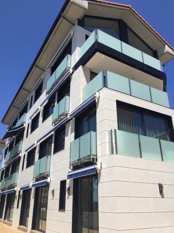 - un bâtiment avec des balcons sur le côté dans l'établissement Apartamentos Playa De Los Barcos, à Isla