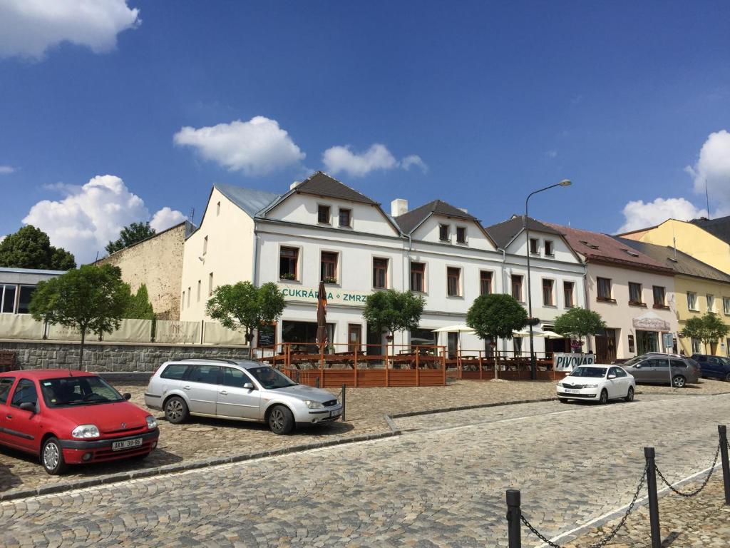 a group of cars parked in front of a building at Apartmány v pivovaru in Kašperské Hory