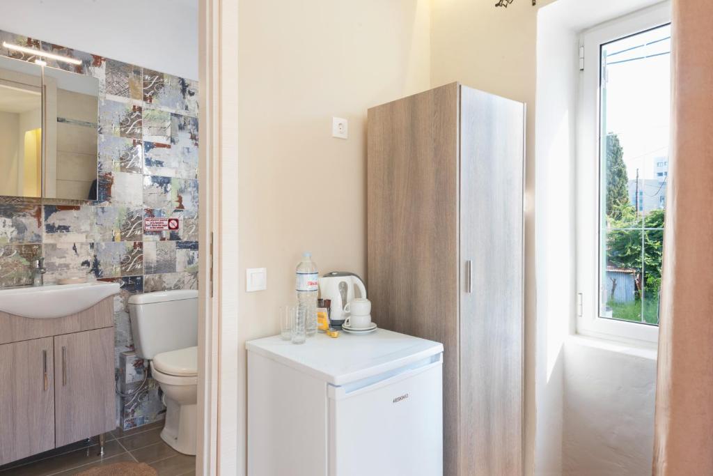 a white bathroom with a toilet and a sink at Takis Family Corfu in Kontokali