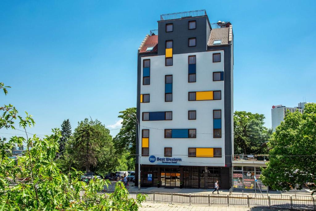 een groot wit gebouw met oranje ramen bij Best Western Terminus Hotel in Sofia