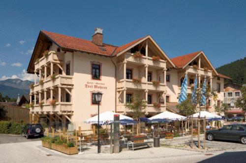 un grande edificio con ombrelloni di fronte di Hotel Drei Mohren a Garmisch-Partenkirchen