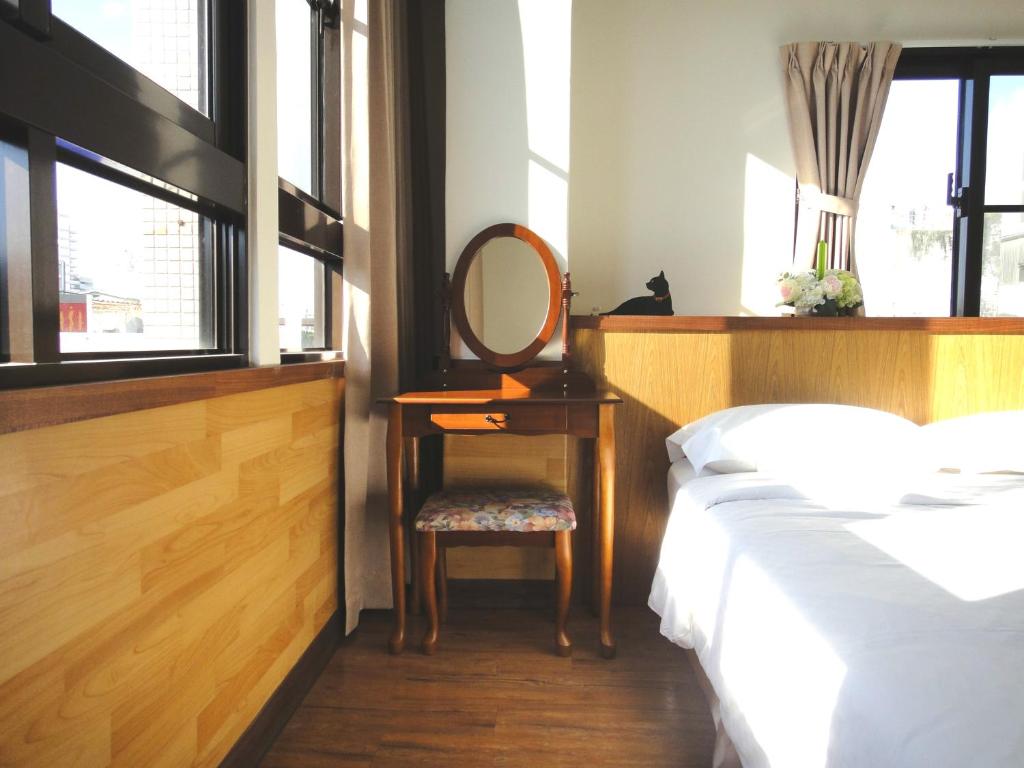 - une chambre avec un lit, un miroir et une chaise dans l'établissement Park 66, à Tainan