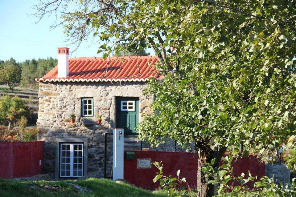 een klein stenen huis met een groene deur bij Casa Do Salgueiral in Fundão