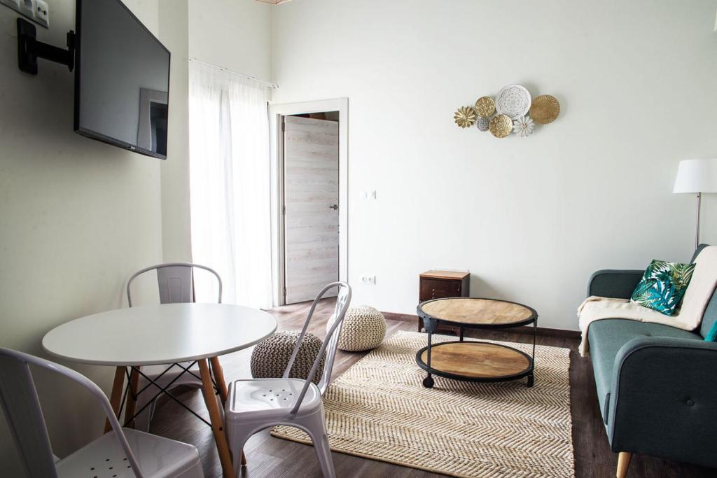 a living room with a couch and a table and chairs at Apartamentos Estela de Altamira in Santillana del Mar