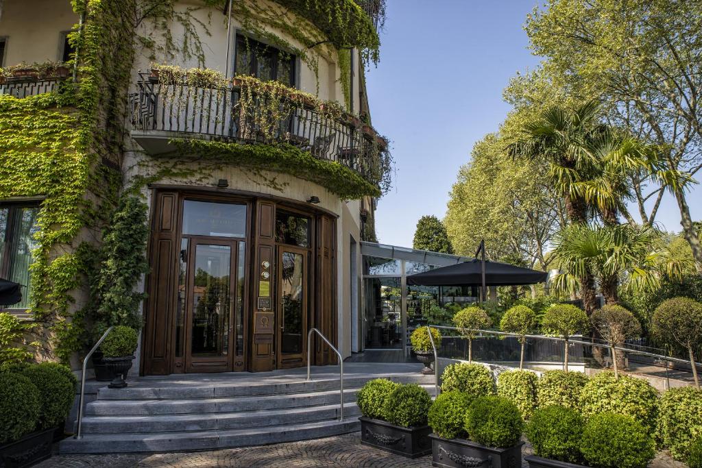 - un bâtiment avec une porte et des escaliers devant dans l'établissement Hotel de la Ville Monza - Small Luxury Hotels of the World, à Monza