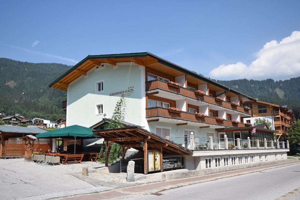 un grand bâtiment avec des balcons sur le côté d'une rue dans l'établissement Gästehaus Waltl, à Krimml