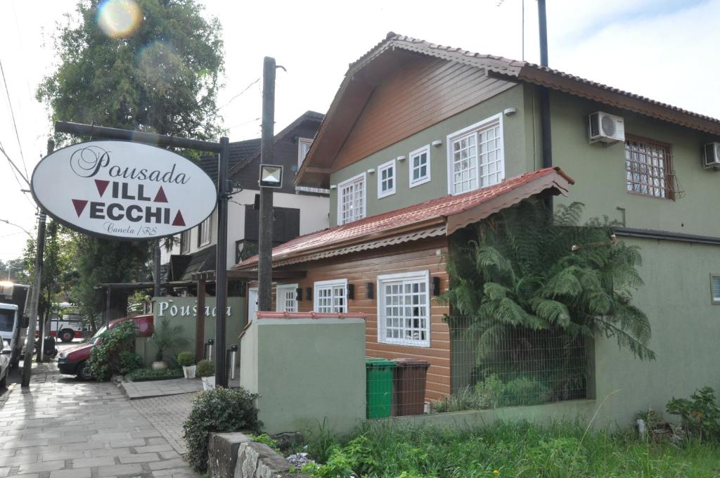 a house with a sign in front of it at Pousada Villa Vecchia in Canela