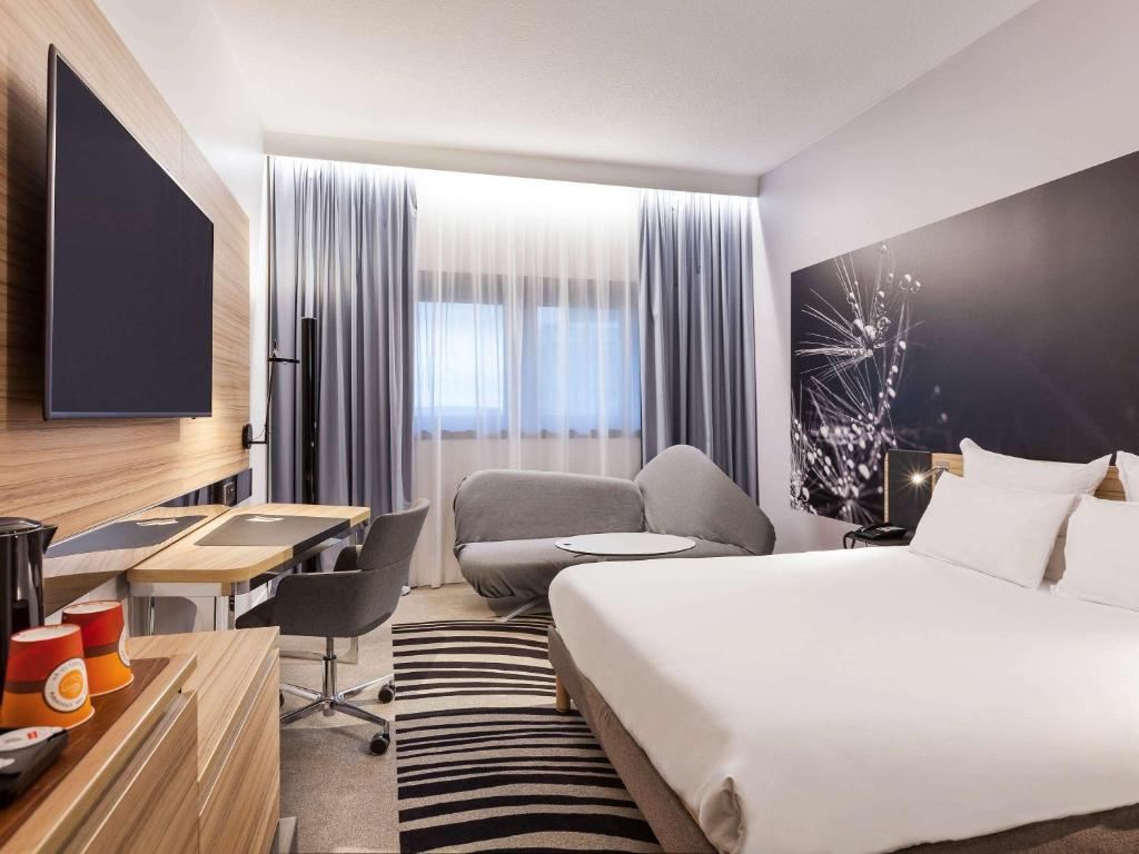 A bed or beds in a room at Novotel Tours Centre Gare