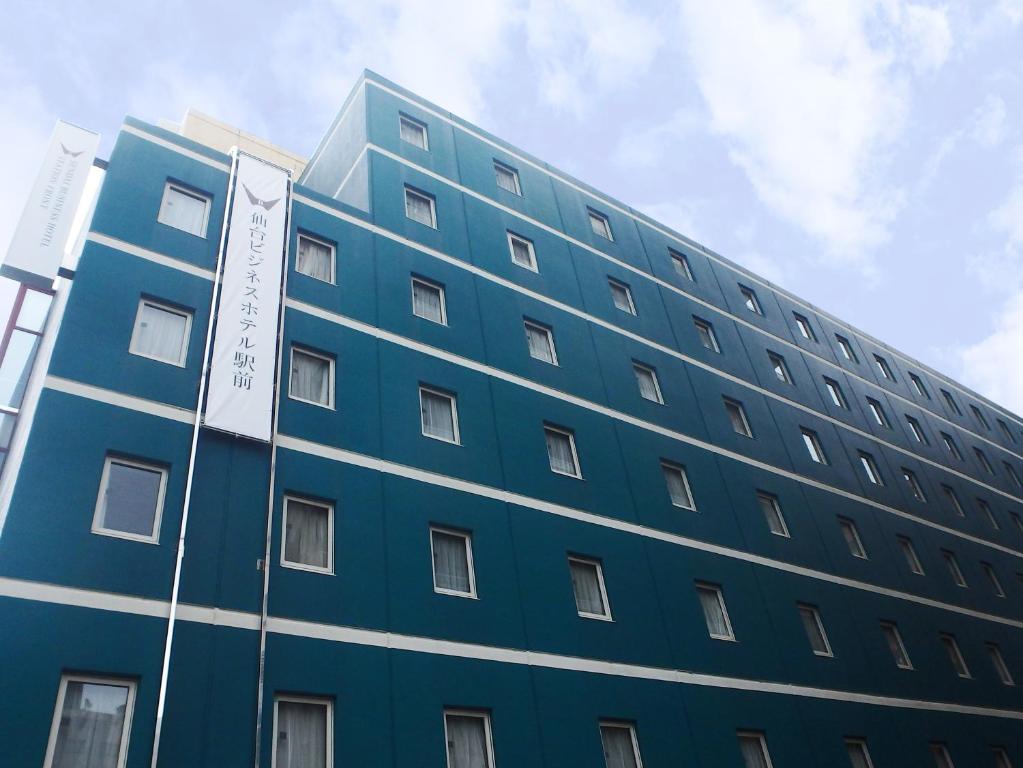 un bâtiment bleu avec un panneau sur son côté dans l'établissement Sendai Business Hotel Ekimae, à Sendai