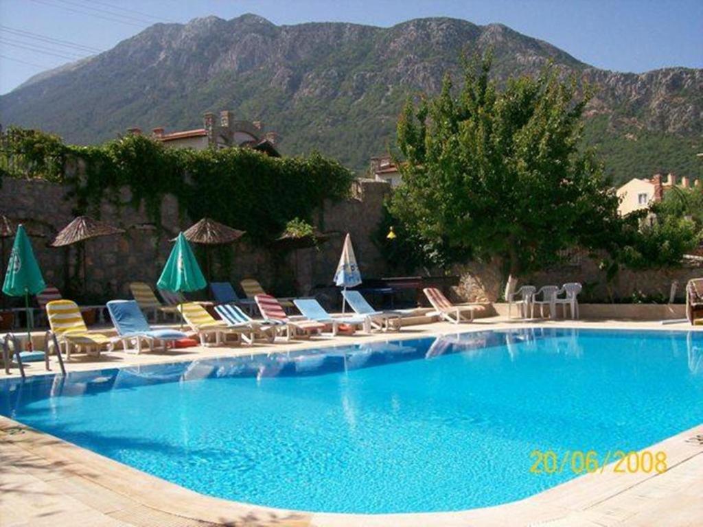 een groot zwembad met stoelen en parasols bij Everest Apart Hotel in Oludeniz