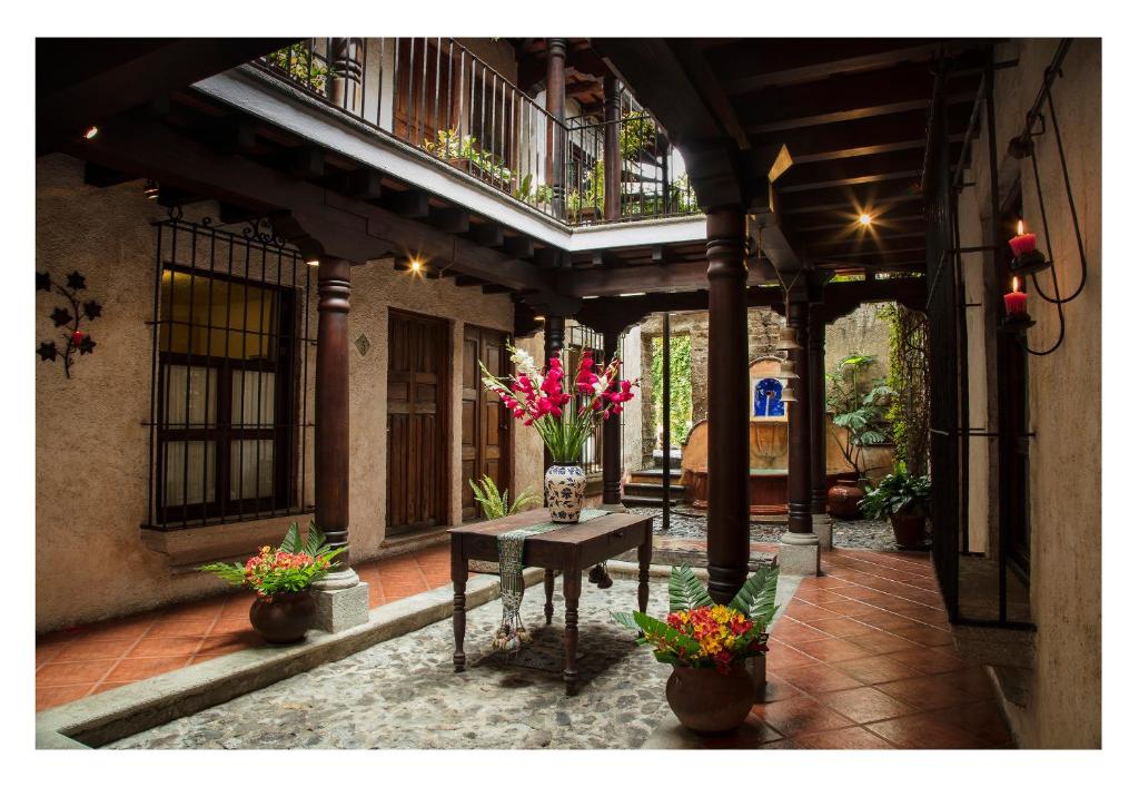 a courtyard with a table with flowers on it at Posada El Antaño in Antigua Guatemala