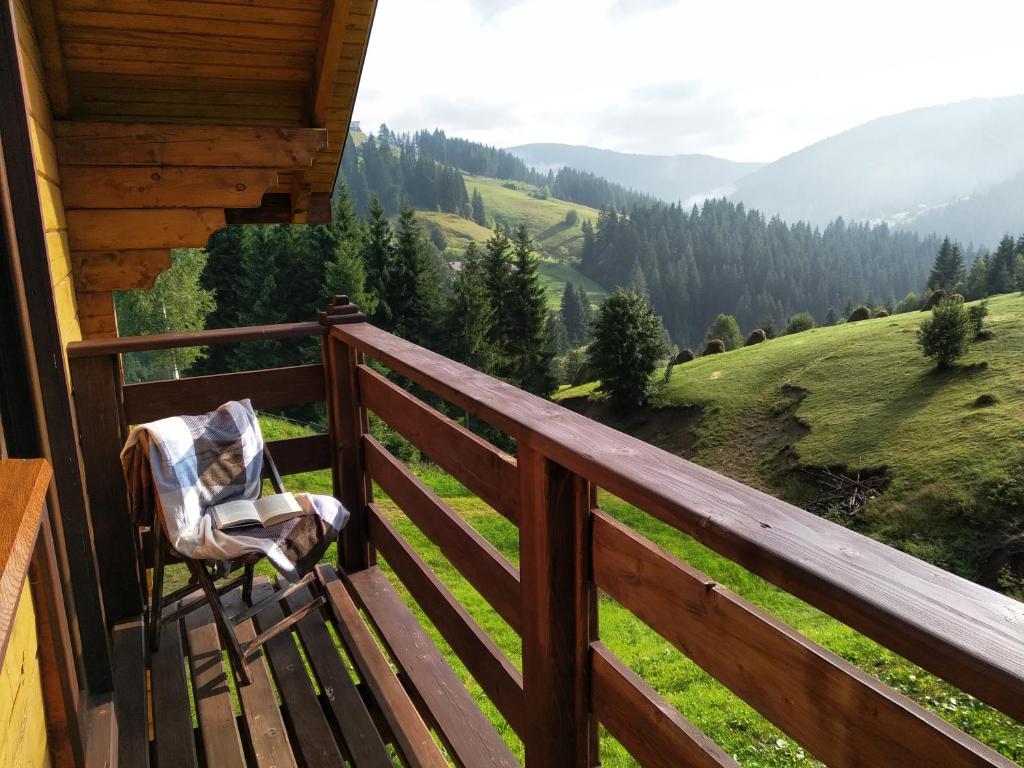 una silla en el balcón de una cabaña con vistas en Пагорб Їжака / Hedgehog Hill, en Yablunytsya