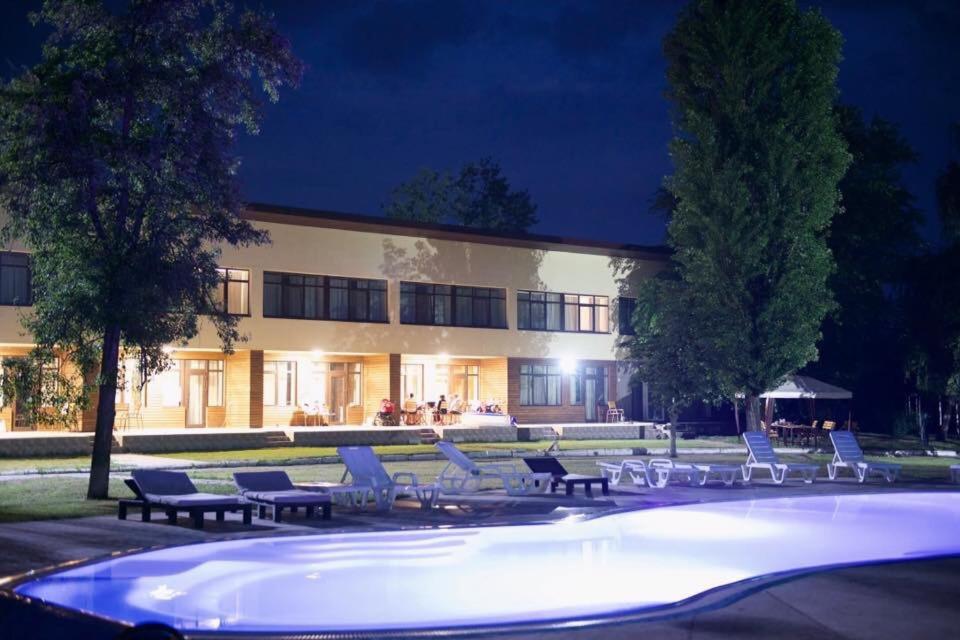 a large building with a swimming pool at night at База відпочинку "РіверСайд" СВІТЛО Є ЗАВЖДИ in Novomoskovsʼk