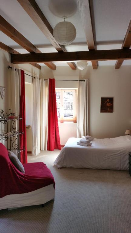 1 Schlafzimmer mit 2 Betten und roten Vorhängen in der Unterkunft Chambres touristiques La Cour Des Hôtes in Obernai