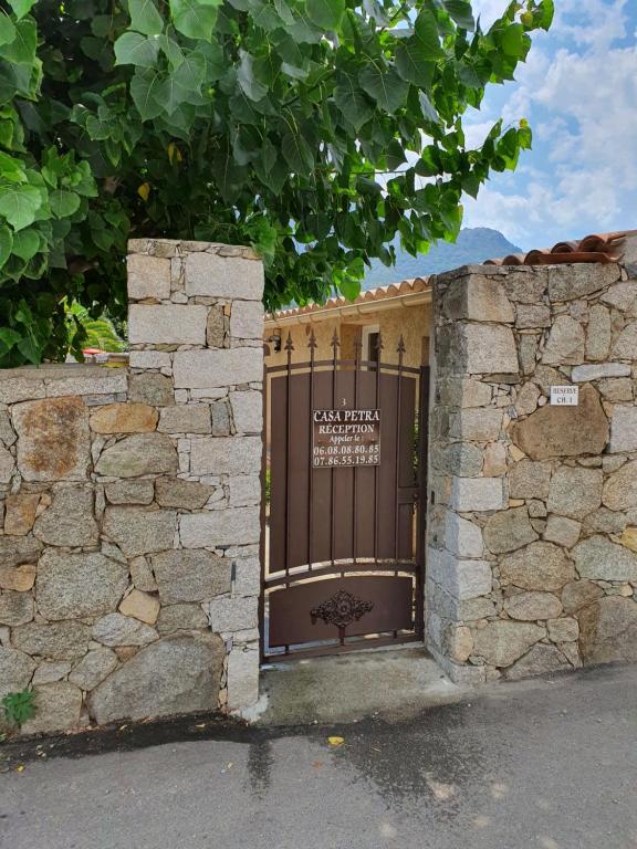 une porte menant à un bâtiment avec un mur en pierre dans l'établissement Casa Petra, à Corte