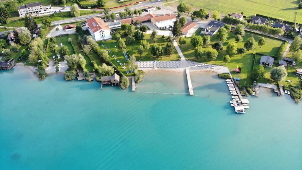 una vista aerea di una casa su un'isola in acqua di Strandhotel Faak a Faak am See