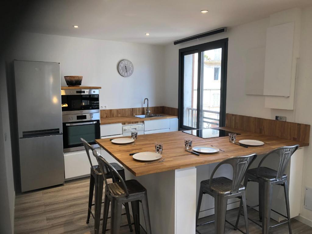 een keuken met een grote houten tafel en stoelen bij Appartement port bonifacio in Bonifacio