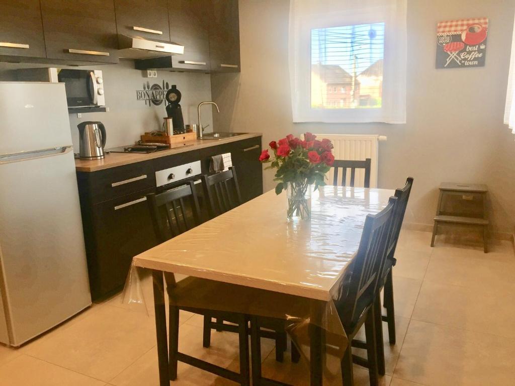 uma cozinha com uma mesa com um vaso de flores em Rentalis Flat em Liège