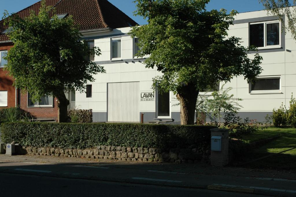 uma casa com uma cerca em frente a um edifício em Lavan em Lovaina