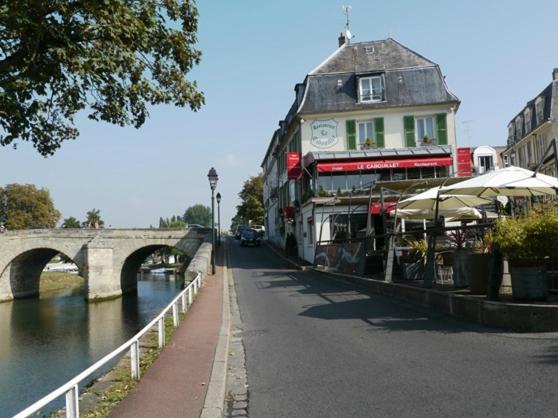 LE CABOUILLET في جزيرة آدم: مبنى على جانب نهر مع جسر