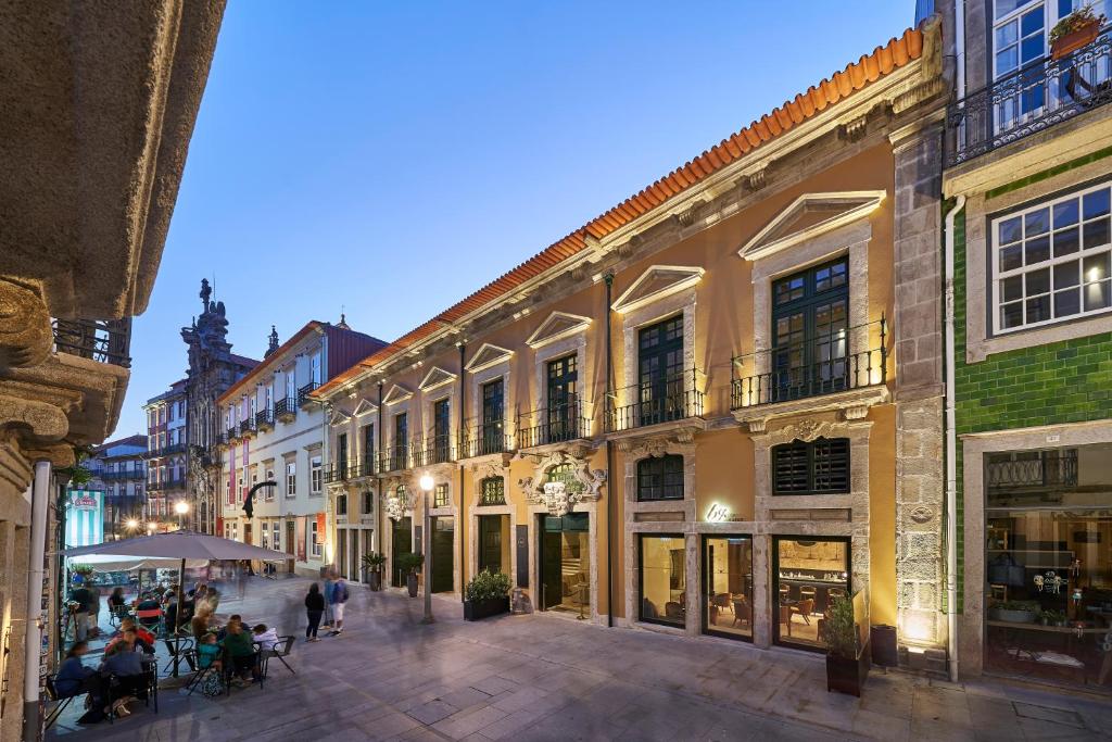 una calle en una ciudad con gente sentada en las mesas en PortoBay Flores, en Oporto