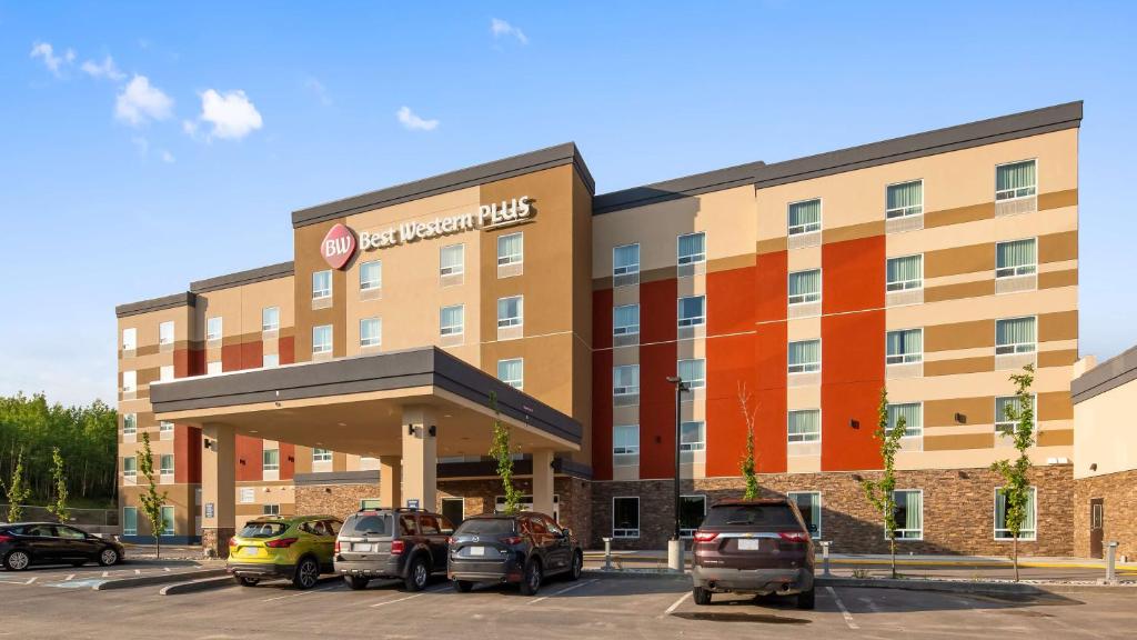 un bâtiment d'hôtel avec des voitures garées dans un parking dans l'établissement Best Western Plus Hinton Inn & Suites, à Hinton